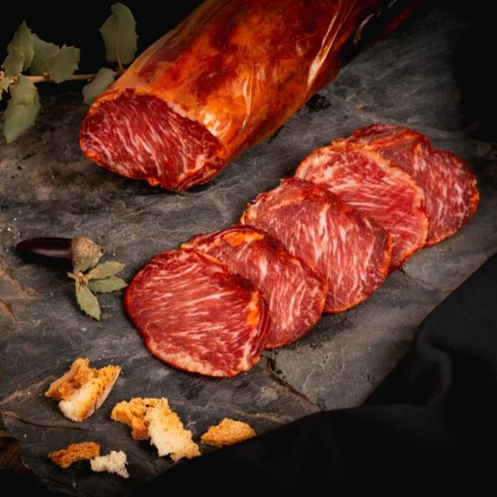 Lonchas de lomo ibérico servidas en una tabla, opción saludable en dietas bajas en azúcares.