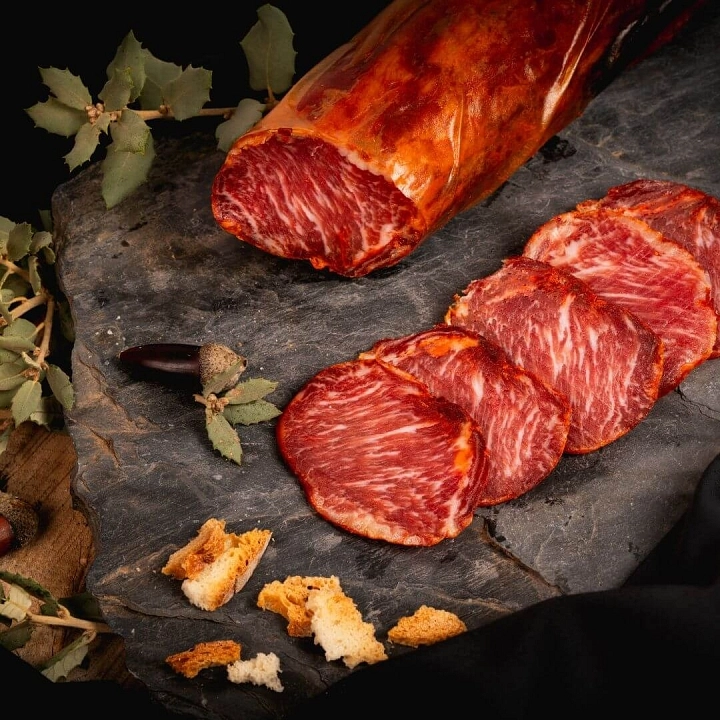 Tabla de lomo ibérico para navidad. Es una tabla de pizarra decorada con pan y bellotas.
